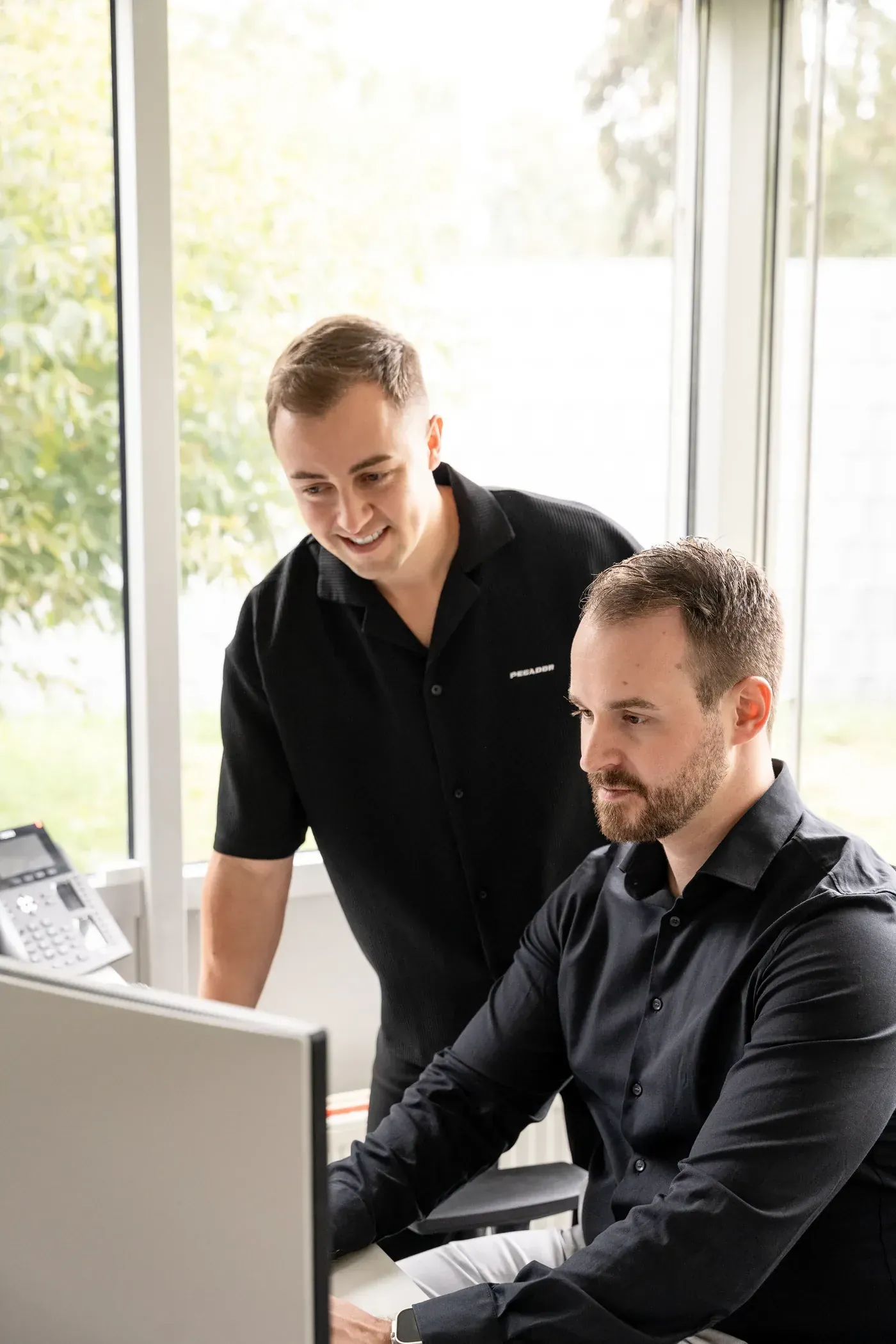 Simon und Sven von Cateon analysieren gemeinsam Daten am Bildschirm